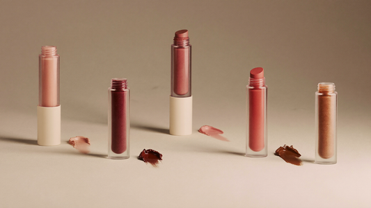 Quatre tubes de tatouage lèvres peel-off Soveya avec leurs nuances Rose Pink, Neutral Mauve, Brown et Cool Cocoa sur fond ivoire et taupe, lumière studio chaude