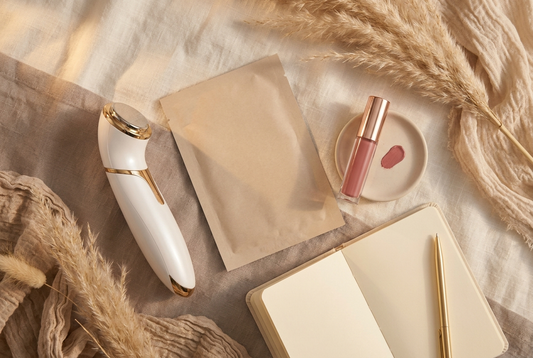 Flatlay beauté premium sur fond ivoire et taupe : appareil LED, masque tissu coréen et tatouage lèvres, ambiance rentrée